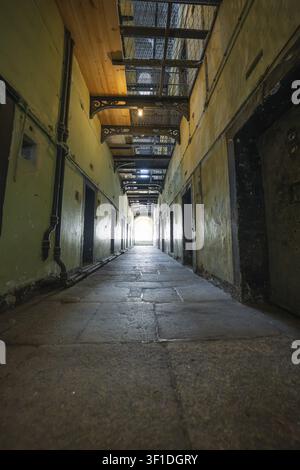 Long yellow prison corridor with lights, Kilmainham Gaol prison, Dublin, Ireland Stock Photo
