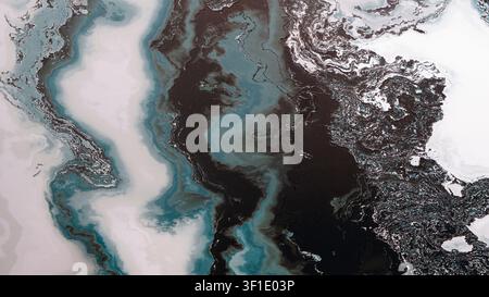 Black and teal liquids swirl on white. Silver specks add metallic highlights. Abstract patterns create dynamic flow. No recognizable elements visible. Stock Photo
