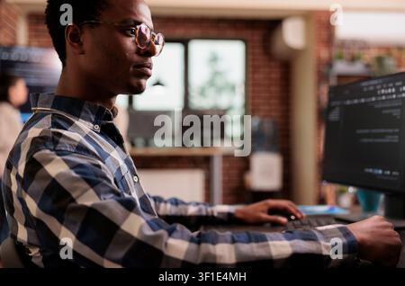 Programmers collaborating on HTML script in terminal window in a programming workspace, connecting source code, database logic and collaborative development for a technology project. Stock Photo