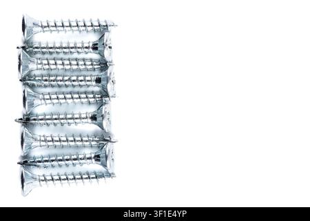 Metal screws arranged neatly in a row against white background. Screws gleam with polished, industrial precision. Clean lines and sharp edges emphasiz Stock Photo