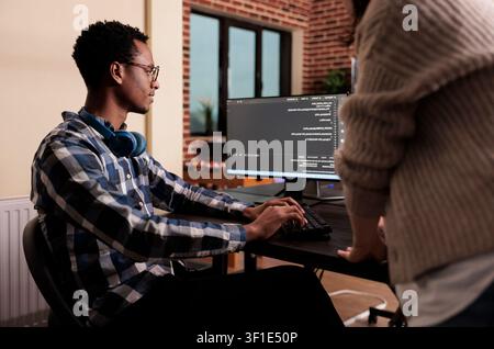 Diverse cloud programmers use computers to develop algorithm programs, build user interfaces and work with terminal windows in a software company. Stock Photo