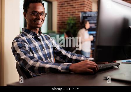 African american developer working on software program in it programming agency, utilizing skills in coding and technology to create more inclusive program, web programer writing html script. Stock Photo