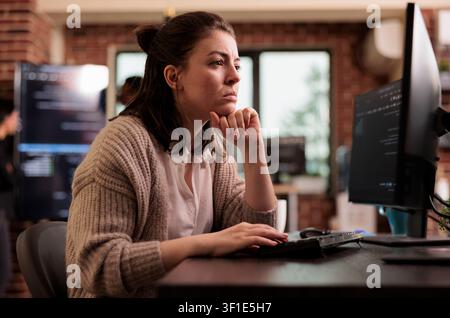 Freelance coder working with html script on terminal window, looking at computer screen and typing, with caucasian tech engineers writing innovating ai algorithm it developing it agency. Stock Photo