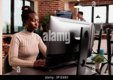 African american tech engineer typing big data code on computer, developing program using html script, Software developer writing ai algorithm working in it programming agency. Stock Photo