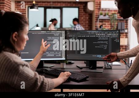 Multiethnic developers building cloud code in server room while working with code, screens and digital infrastructure for software development. Stock Photo
