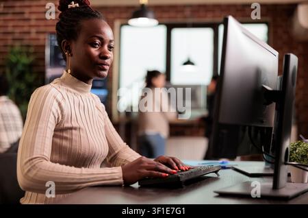 Software developer brainstorming ideas to write code and create new interface in data room. Tech enginner sitting at desk programming server database, working in busy it agency. Stock Photo