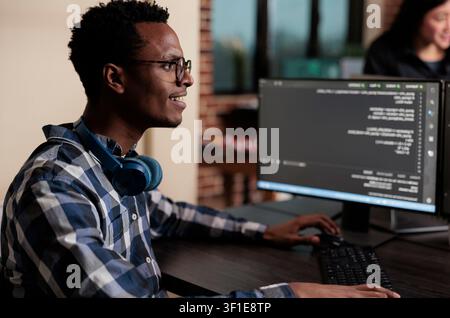 Smiling African American software engineer develops a machine learning algorithm to support system security stability and binary network encryption. Stock Photo
