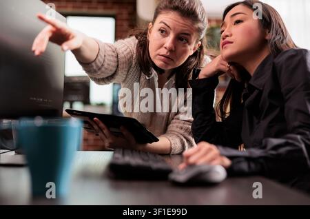 Software engineers collaborating on coding project presenting discussing about programming algorithm for new cloud computing working in it company. Stock Photo