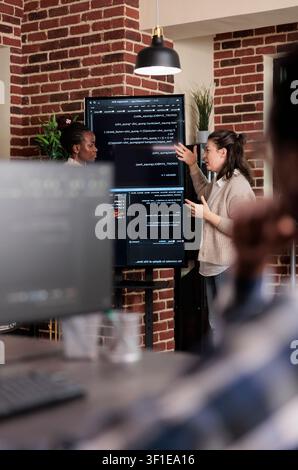 Multiethnic developers discuss rising system security breaches while working on storage problems and artificial intelligence solutions. Stock Photo
