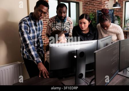 Cyber security team develops software processing algorithm during a indoor setting moment involving african american, brick wall and multiethnic cyber Stock Photo
