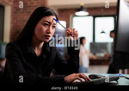 Thoughtful developer planning encryption program upgrade during a focused IT task involving diagnostics, digital infrastructure and secure data processing. Stock Photo