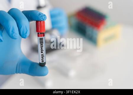 Close-up of a gloved researcher holding a blood vial labeled Ebola Virus in a lab, conveying medical testing, infectious disease diagnosis, virology r Stock Photo