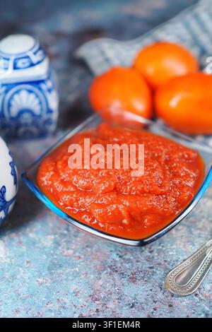Fresh tomato sauce and oranges on a kitchen table Stock Photo