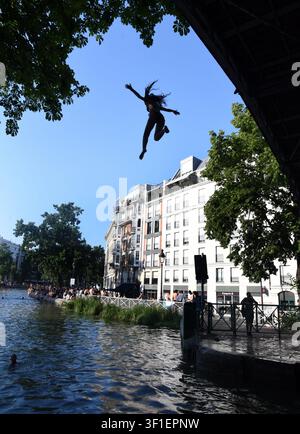 Paris, France. 12th July, 2026. Tourists and parisians cool themselves at Canal Saint-Martin as a Heatwave hits in Paris, 40｡C expected towards temperature records in France on July 12, 2026. Photo by Alain Apaydin/ABACAPRESS.COM Credit: Abaca Press/Ģ����ý Live News Stock Photo
