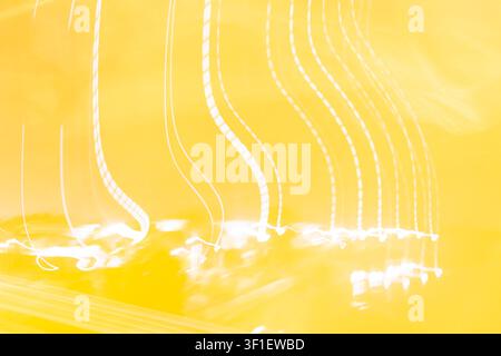 Abstract yellow light trails with glowing curved lines and long exposure motion creating vibrant luminous background suitable for modern creative tech Stock Photo