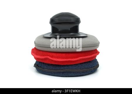 A stack of colorful car care applicators including foam pads and microfiber cloths with a black ergonomic handle for easy grip during cleaning tasks Stock Photo