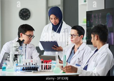 Multiethnic Medical Team Reviewing Lab Results in Research Meeting Stock Photo