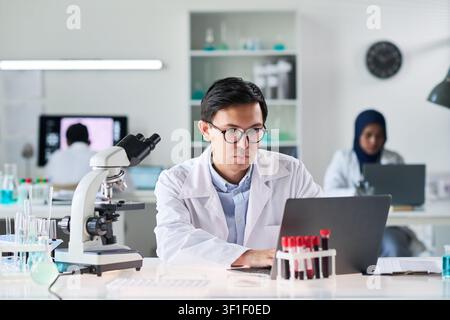 Asian Man Researcher Working on Laptop in Medical Laboratory Stock Photo
