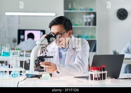 Asian Male Scientist Analyzing Samples in Medical Research Lab Stock Photo
