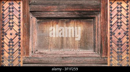 Texture of vintage wood board with decorative border with metal rivets. Vertical or horizontal retro background with old wooden plank and aged iron re Stock Photo