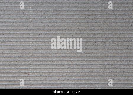 Close up view of brown corrugated cardboard texture with horizontal ridges and visible dark fibers. Natural packaging material background for eco desi Stock Photo