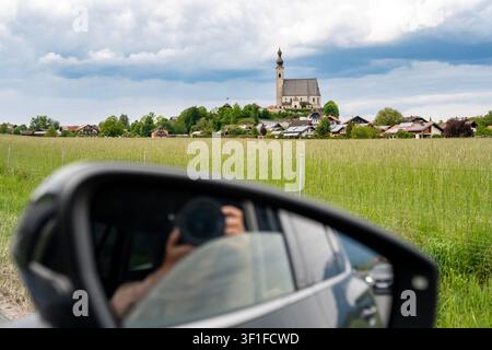 Catholic church of the Assumption of Mary seen from car window while travelling through green fields in rural Bavaria, Germany. High quality photo Stock Photo