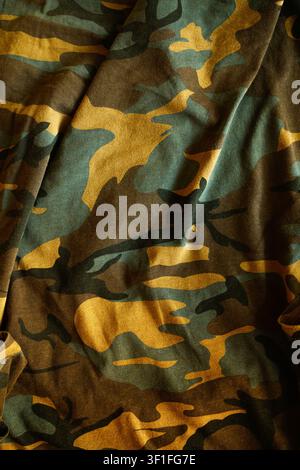 Textured background of a classic woodland camouflage pattern on creased cloth with natural shadows and highlights. Top view. Stock Photo