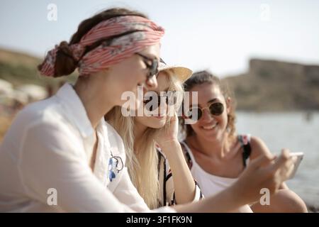 Three young women friends taking selfie at beach Stock Photo