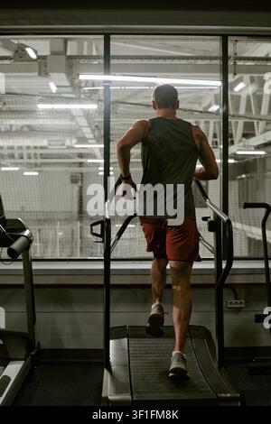 Man Running on Treadmill in Gym for Fitness Training Stock Photo
