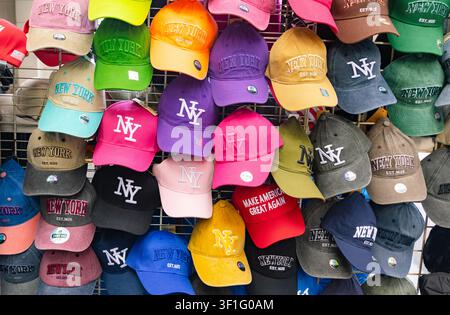 New-York, USA - 13.08.2026: Display of colorful New York baseball caps and hats hanging on a street market wall Stock Photo