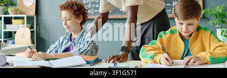 Schoolchildren Studying with Teacher Support in Classroom Stock Photo