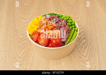 "Fresh Poke Bowl with Salmon, Tuna, Edamame, Cherry Tomatoes and Mango in Paper Container" Stock Photo