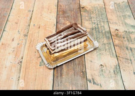"Rectangular Slice of Black Forest Cake with Chocolate Curls and Powdered Sugar on Foil Tray" Stock Photo