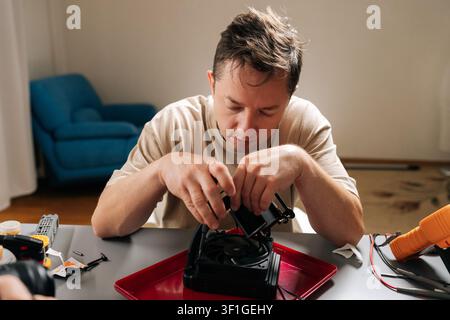 Focused technician performing computer hardware maintenance, installing cpu cooling system, ensuring optimal performance for modern gaming or Stock Photo