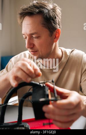 Vertical portrait of young man repairing and installing computer liquid cooling system, showcasing pc building, technical support. Concept of computer Stock Photo