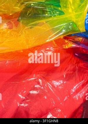 Abstract colorful background created by crumpled plastic sheets in bright red, yellow, green and blue hues. Shiny textures, vibrant colors suggest joy Stock Photo