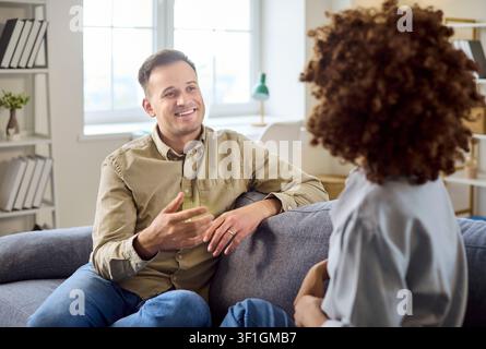 Happy talking on sofa at home, open communication and relationship bonding Stock Photo