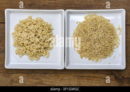 A top-down view of two white square ceramic plates showing a clear comparison between cooked Thai Hom Mali jasmine brown rice with plump soft grains Stock Photo