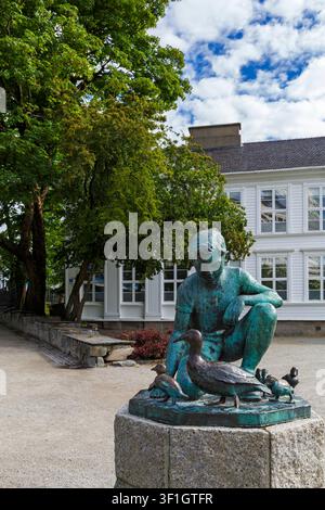 sculpture statue of boy feeding ducks in Byparken, City Park by lakeside of Lake Breiavatnet at Stavanger, Norway, Scandinavia, Europe in June Stock Photo