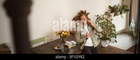 Portrait of handsome office manager, guy in co-working space, talking on mobile phone, calling someone, laughing and smiling, having pleasant conversa Stock Photo