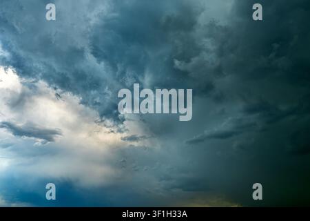 Dramatic storm clouds spreading across blue sky before rain Stock Photo