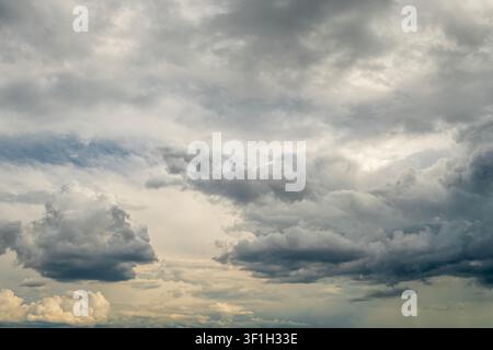 Dramatic storm clouds spreading across blue sky before rain Stock Photo