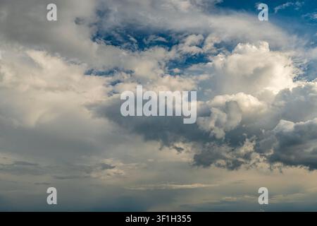 Dramatic storm clouds spreading across blue sky before rain Stock Photo