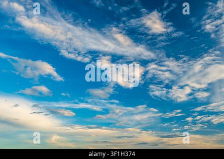 Dramatic sunset sky with dark cumulus and golden orange clouds Stock Photo