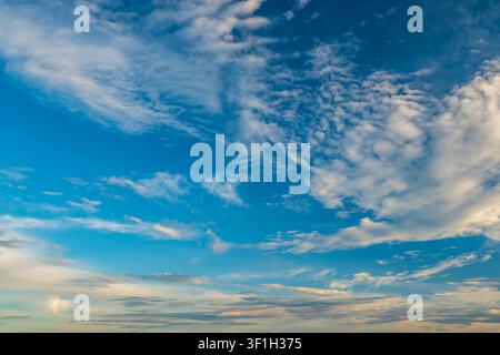 Dramatic sunset sky with dark cumulus and golden orange clouds Stock Photo