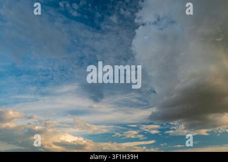 Dramatic sunset sky with dark cumulus and golden orange clouds Stock Photo