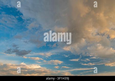 Dramatic sunset sky with dark cumulus and golden orange clouds Stock Photo