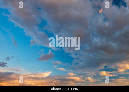 Dramatic sunset sky with dark cumulus and golden orange clouds Stock Photo