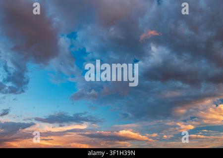 Dramatic sunset sky with dark cumulus and golden orange clouds Stock Photo