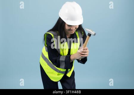 Female construction worker holding drill tool ready for renovation work Stock Photo